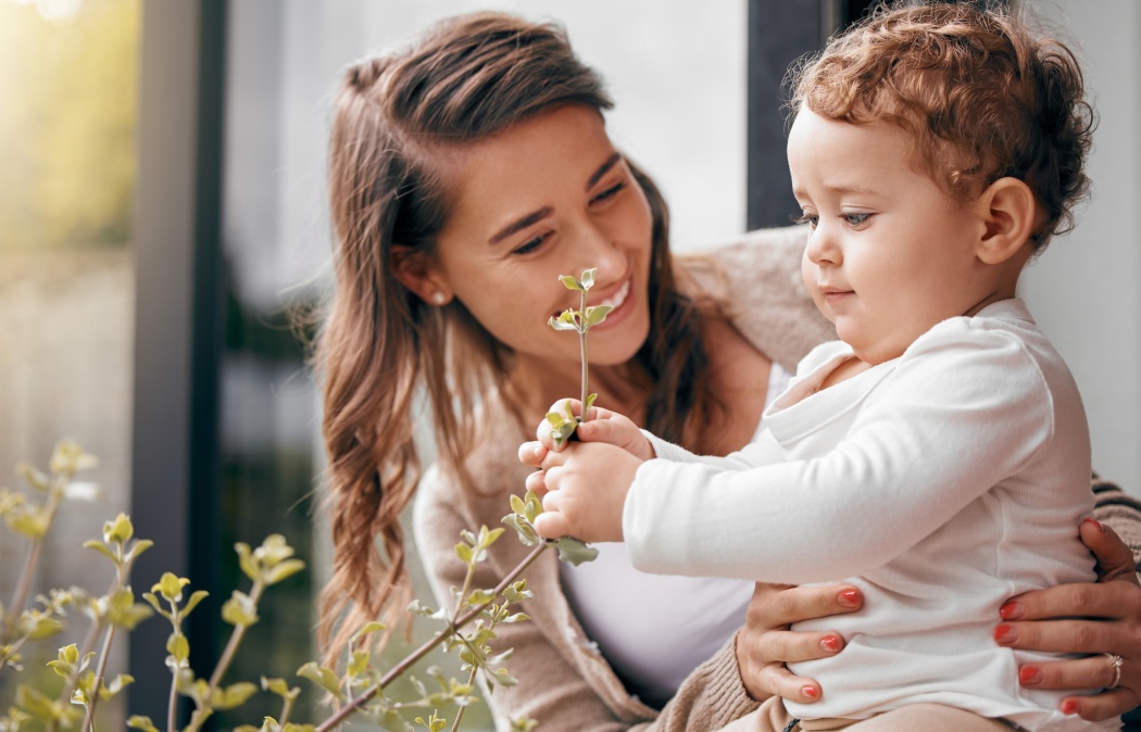 Happy woman, baby and together on porch for love, development and bonding at home. Mom, curious boy and touching plants outside for growth, trust and smiling with hug for joy, protection and wellness